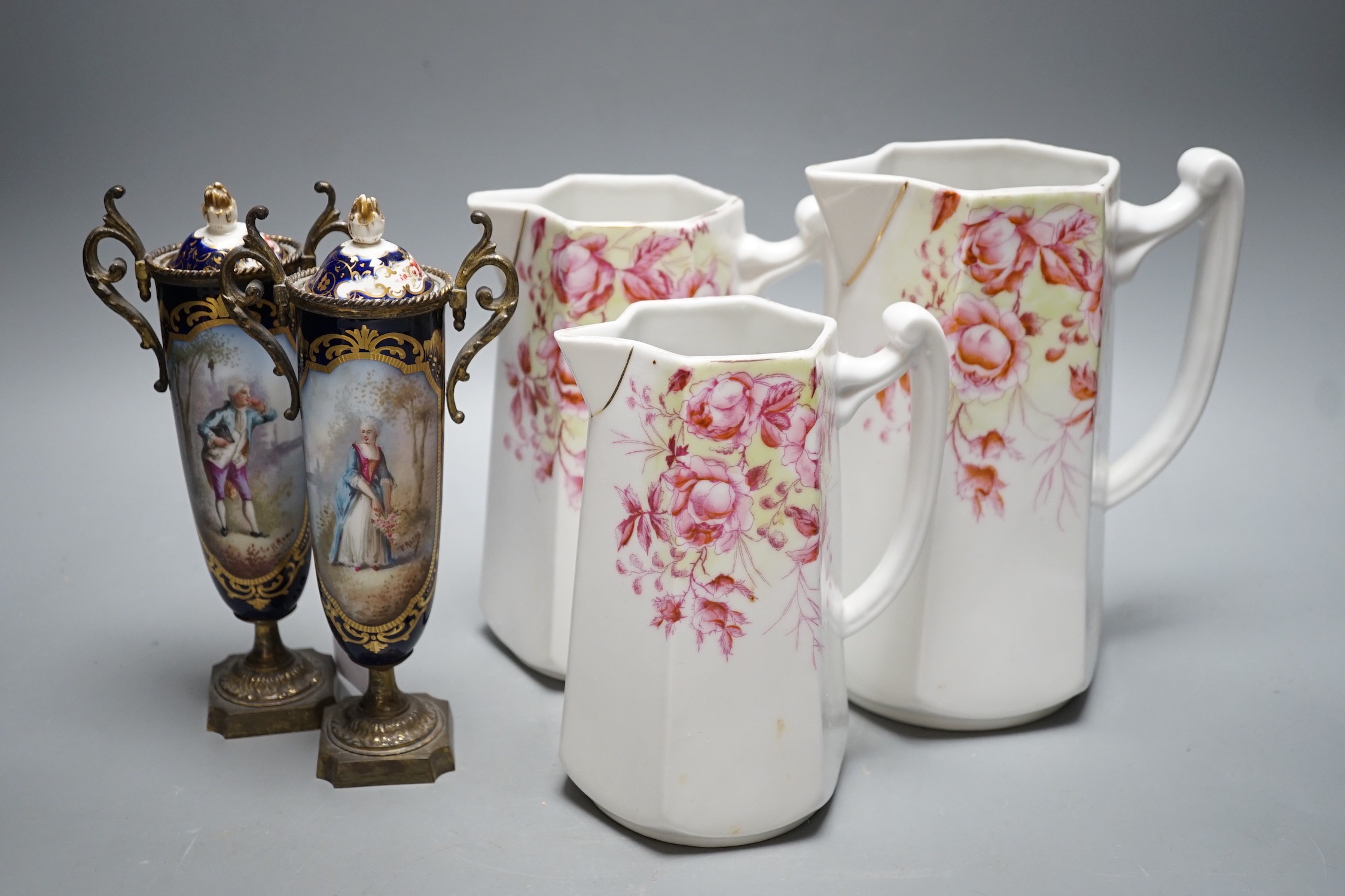 A pair of 19th century French porcelain and gilt metal vases and graded set of three continental porcelain jugs, vases 19cms high